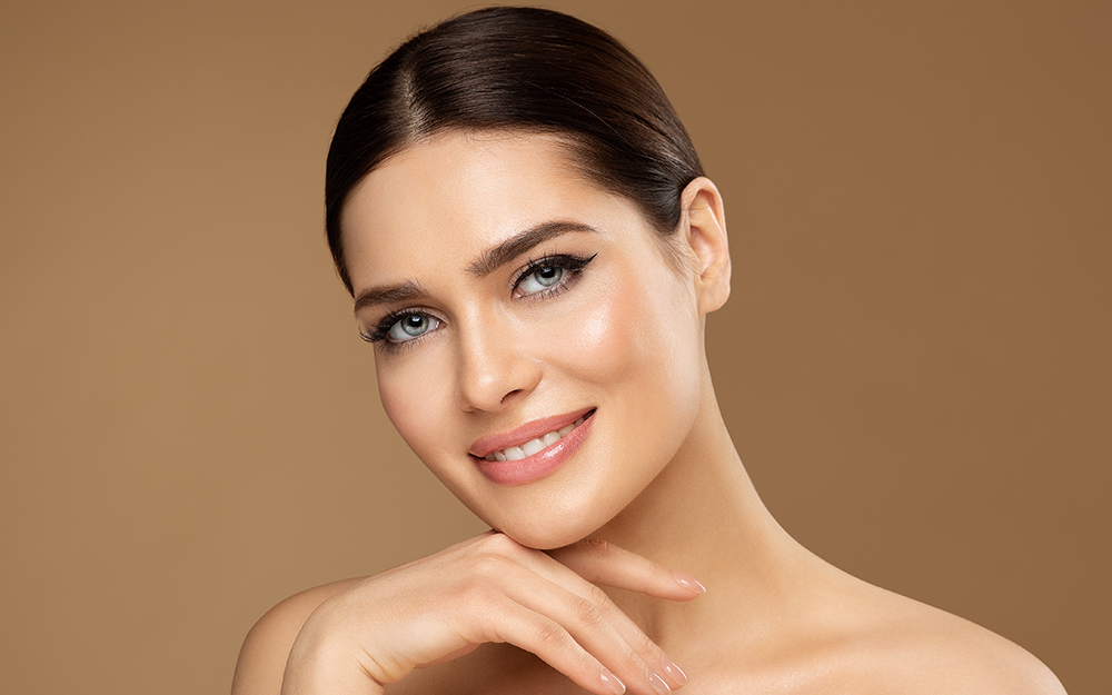 Smiling Woman with natural Make up touching Facial Healthy Skin
